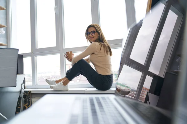 Feliz fotógrafa relajándose con café en el estudio — Foto de Stock