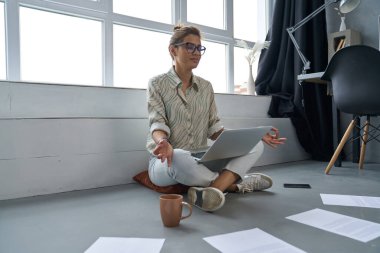 Huzurlu genç kadın içeride aletlerle meditasyon yapıyor.