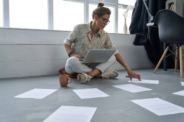 Evde internette çalışan genç bir iş kadını.