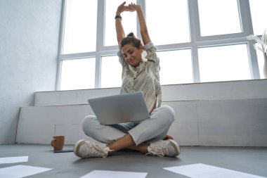 Gülümseyen kadın iş için kapalı alanda defter kullanıyor.