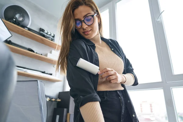 Happy young female tidying up blouse in office — Stock Photo, Image