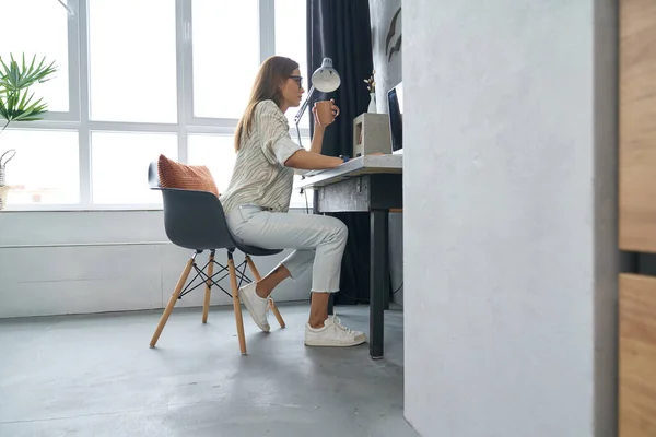 Елегантна жінка з кавоваркою онлайн вдома — стокове фото
