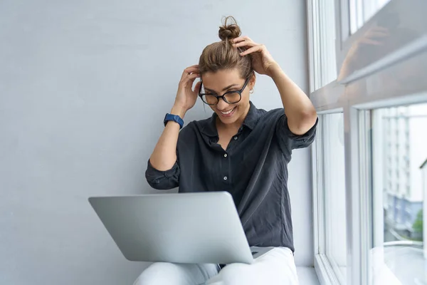 Glada unga kvinnliga avkopplande med laptop inomhus — Stockfoto