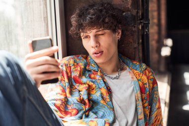 Cep telefonuyla fotoğraf çeken şık bir adam.