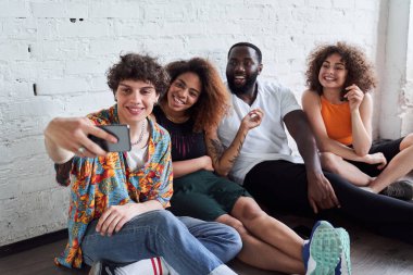 Cep telefonuyla fotoğraf çeken mutlu gençler