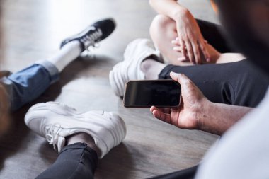 Elinde cep telefonu tutan beyaz bir adam.