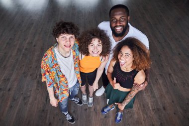 Gülümseyen erkekler ve kadınlar kameraya birlikte poz veriyorlar.