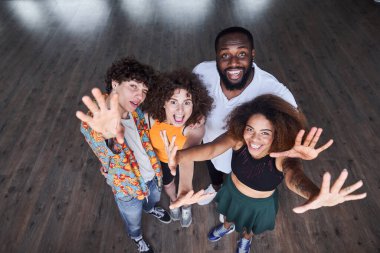 Mutlu genç arkadaşlar stüdyoda el ele tutuşuyorlar.