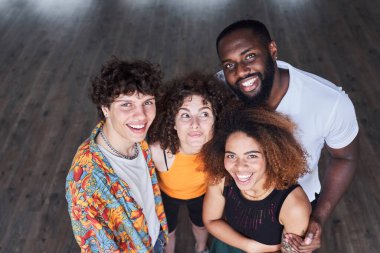 Mutlu genç arkadaşlar stüdyoda kucaklaşıyorlar.