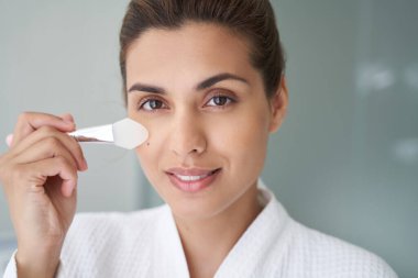 Gülümseyen bayan, en sevdiği aleti cilt bakımı için kullanıyor.