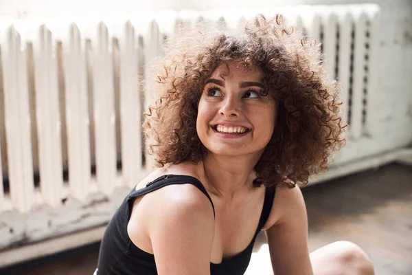 Mutlu güzel bayan dans stüdyosunda yerde oturuyor.