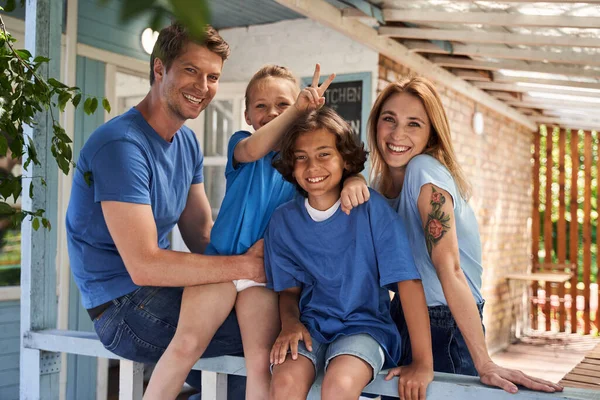 Щаслива любляча сім'я позує на передньому ганку свого будинку — стокове фото
