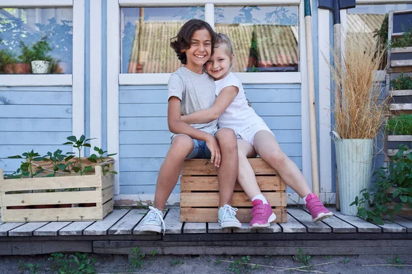 Linda niña y niño abrazándose fuera de la casa —  Fotos de Stock