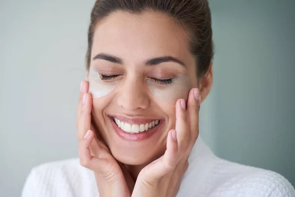 Mulher encantada com manchas sob os olhos sorrindo — Fotografia de Stock