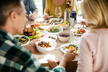 Gülümseyen erkek, evde kız arkadaşına yemek dolduruyor.