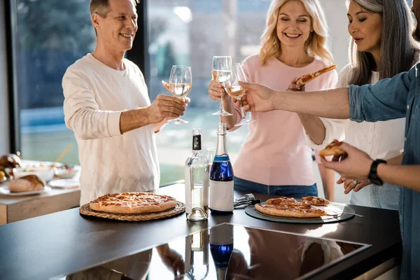 Happy adult people making toast with glasses of wine