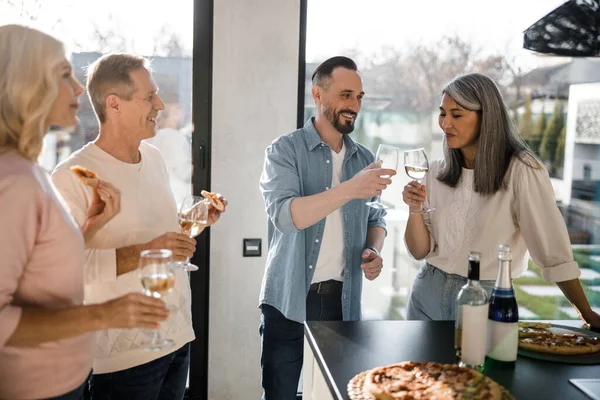 Felice amici adulti godendo di vino a casa — Foto Stock