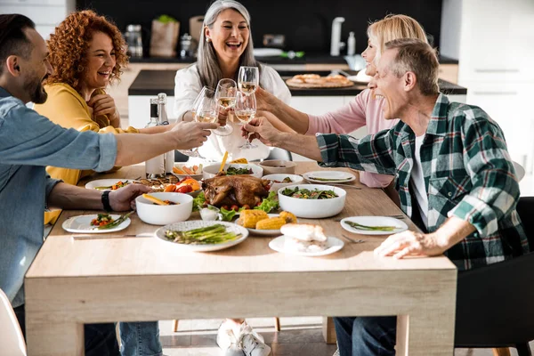 Homens e mulheres alegres comemorando o dia de ação de graças juntos — Fotografia de Stock