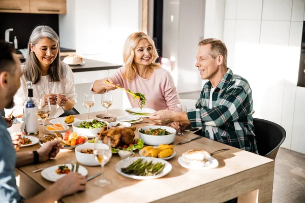 Lachende volwassen man met bord aan de feestelijke tafel — Stockfoto