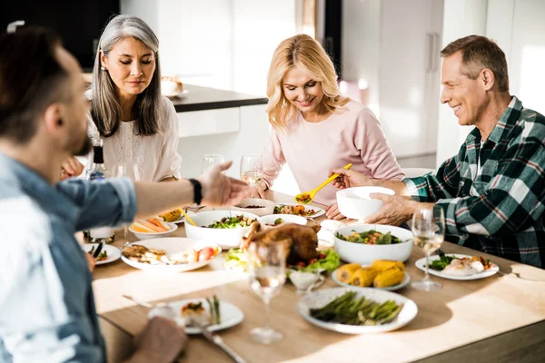 Glückliche Freunde beim gemeinsamen Essen im Wohnzimmer — Stockfoto