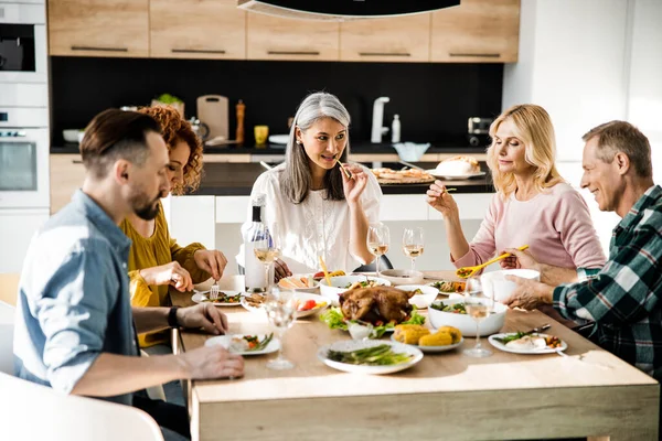 Venner spiser sammen i stuen - Stock-foto