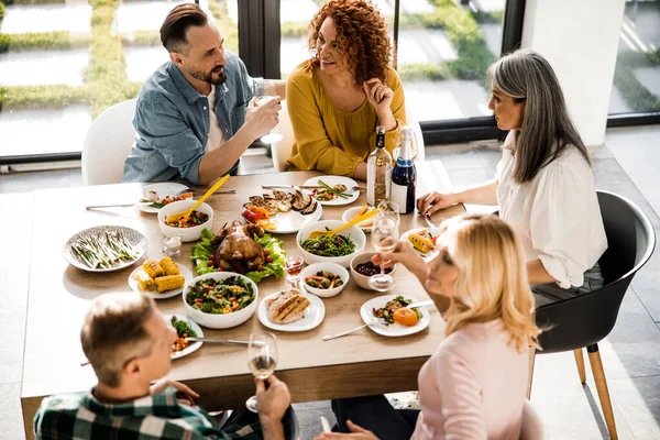 Gelukkige vrienden die samen tijd doorbrengen tijdens feestelijk diner — Stockfoto