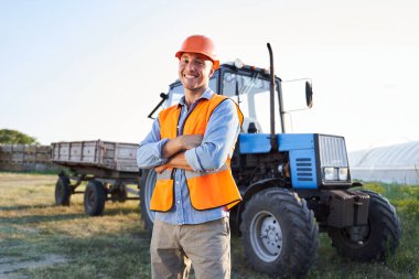 Aracın yanındaki turuncu ceketli eleman.