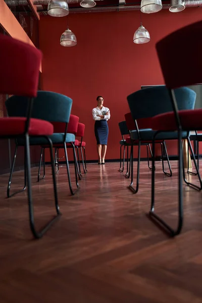Mulher de pé em frente cadeiras no escritório — Fotografia de Stock