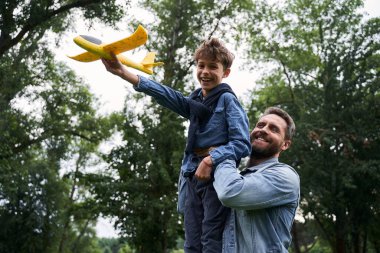 Mutlu baba ve oğul dışarıda birlikte eğleniyorlar.