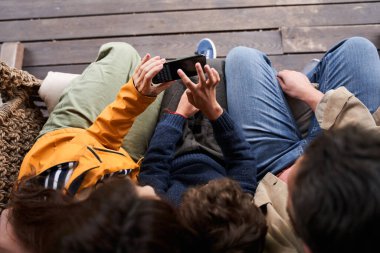 Ebeveynler ve oğulları dışarıda cep telefonu kullanıyorlar.