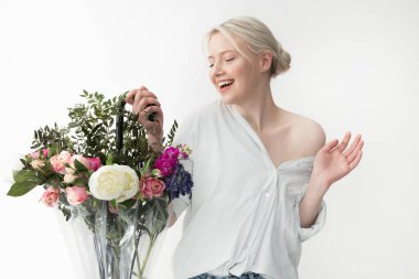 Güzel bir buketi olan, şemsiyeli genç ve çekici bir kadın.