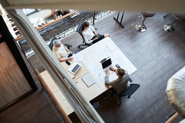 Três pessoas de negócios compartilhando um espaço de trabalho — Fotografia de Stock