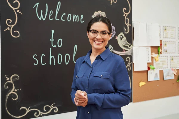 Mujer feliz dando la bienvenida a los alumnos a la primera lección — Foto de Stock