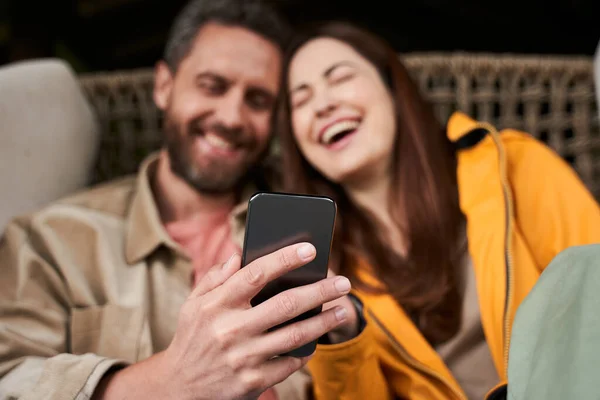 Veselý mladý pár pomocí mobilního telefonu venku — Stock fotografie
