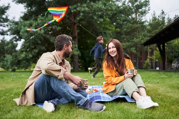Веселые муж и жена наслаждаются пикником на открытом воздухе — стоковое фото