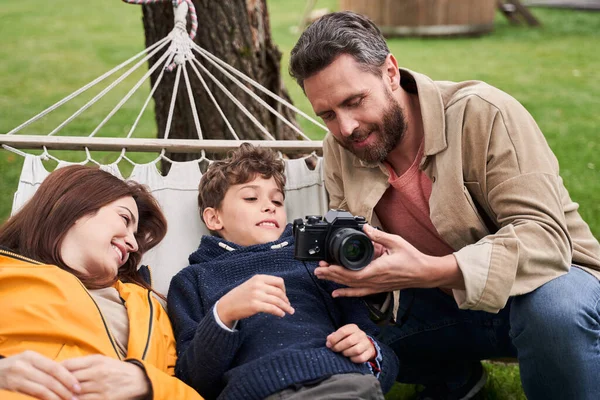 Šťastná rodina pomocí fotoaparátu při společném odpočinku venku — Stock fotografie