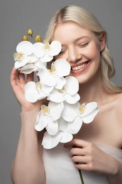 Весела молода жінка тримає красиву білу орхідею — стокове фото