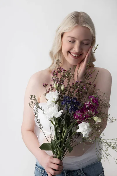 Vidám fiatal nő virágokkal áll szemben a fehér háttér — Stock Fotó