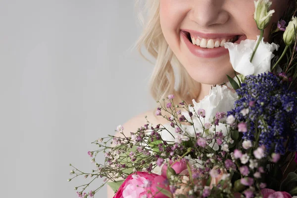 Весела леді з квітами, що стоять на білому тлі — стокове фото