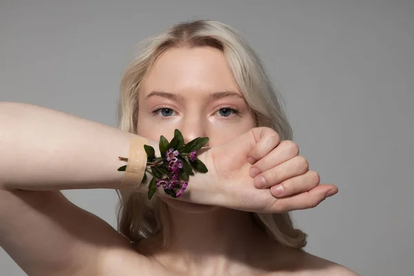 Okouzlující mladá žena ukazuje svou ruku s květinami — Stock fotografie