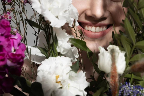 快乐的年轻女子站在美丽的花朵后面 — 图库照片