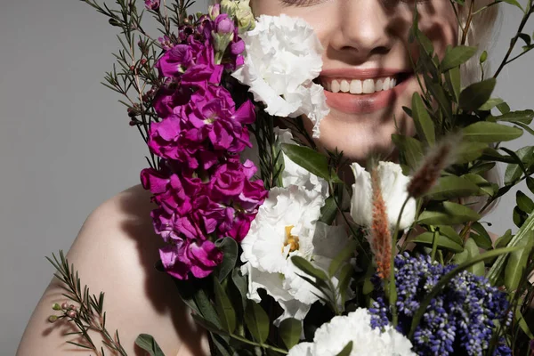 Vreugdevolle jonge vrouw staan achter mooie bloemen — Stockfoto