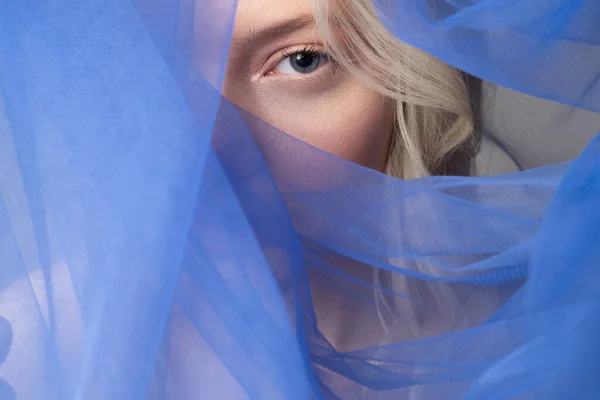 Чарівна молода жінка вкриває обличчя синьою завісою — стокове фото