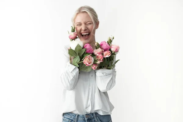 Щаслива молода жінка притискає руки квітами до грудей — стокове фото