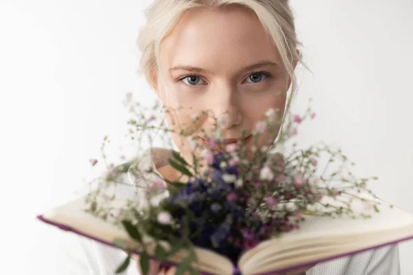 Bájos fiatal nő gazdaság könyv virágokkal — Stock Fotó
