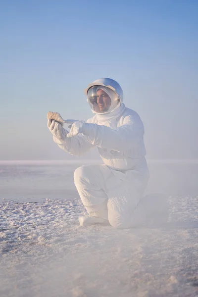 Космонавт в костюме смотрит на камень — стоковое фото