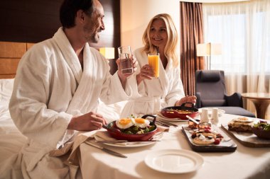 Su ve meyve suyu içerken birbirine bakan çift.