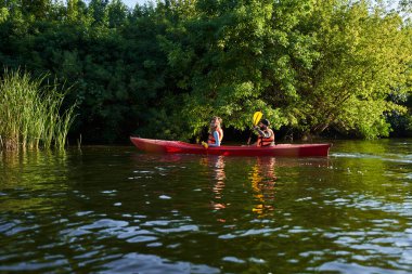 Kanoyla gezen insanlar nehirde rafting yapıyor