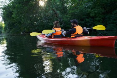 Kanoyla gezen insanlar nehirde rafting yapıyor