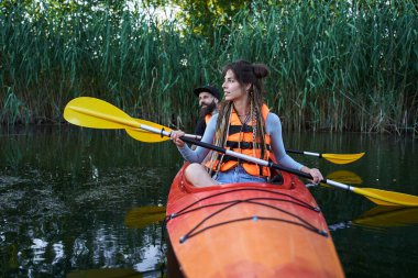 Güzel genç çift gölde kayak yapıyor.